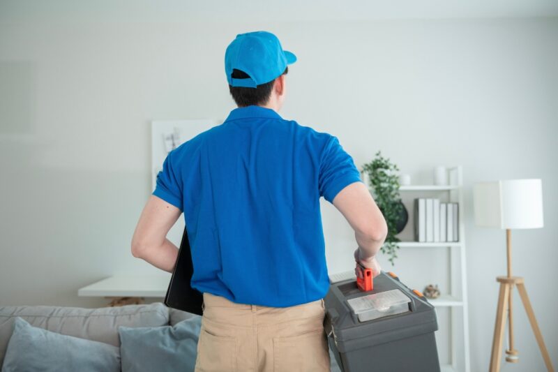 muškarac nosi u rukama alat za popravljanje klima uređaja